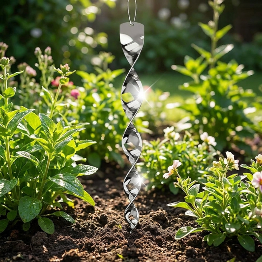 Reflective bird deterrent spiral rod staked in a garden bed glinting in sunlight