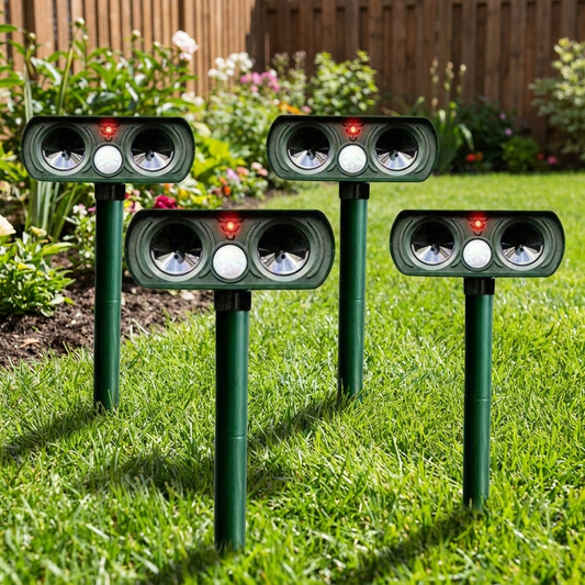 Infrared solar powered animal pest repeller staked in a backyard garden lawn