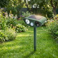 Solar-powered ultrasonic animal repellent staked in a backyard garden lawn