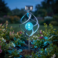 Solar wind chime spinner glowing in a garden at dusk