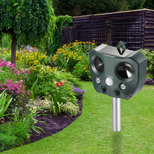 Solar ultrasonic animal repeller staked in a garden bed