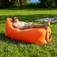 Person relaxing on an outdoor air lounger on grass