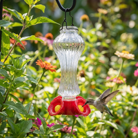 Glass hummingbird feeder hanging in a garden