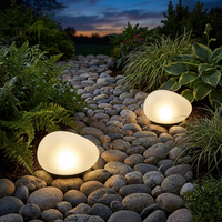 Solar pebble light glowing along a garden path