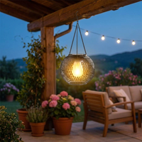 Solar hanging lantern glowing on a patio at dusk