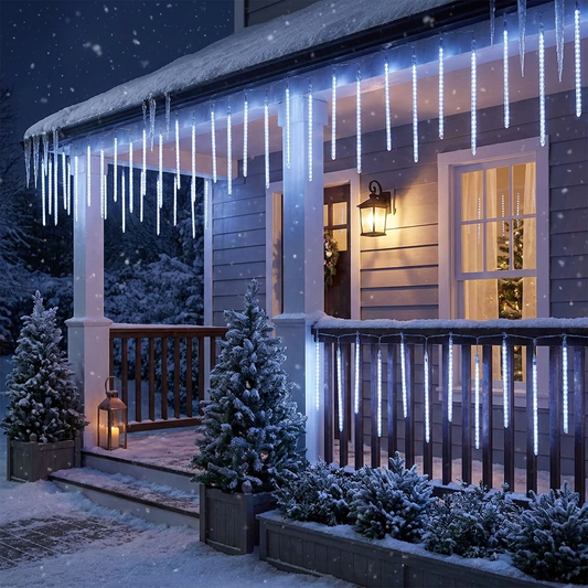 Snowfall garland lights decorating a home porch exterior at night